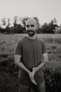 Black and white headshot in wildflower field