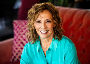 Picture of Wendy, with shoulder-length, wavy auburn hair, and wearing turquoise-colored top.