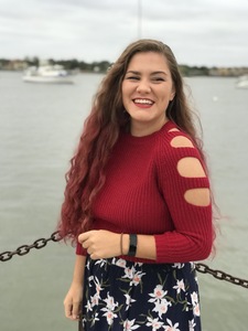 Hadley H. Hudson standing in front of a pier smiling