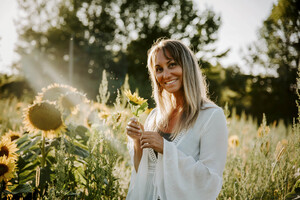 A.D. Vancise, award-winning author of Hidden in the Shadows, photographed in a sunflower field.