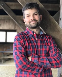 John Christopher Frame standing in a barn