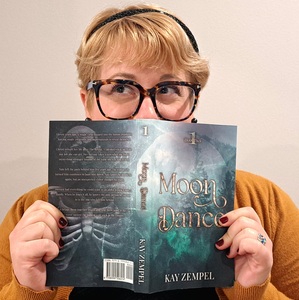 Woman with glasses holding a book 