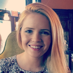 A headshot of a blonde, white woman smiling