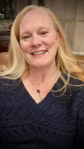 tia Levings a strawberry blond woman in a blue sweater smiles