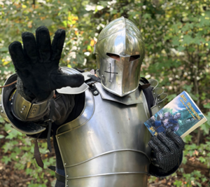 man in armor holding a book