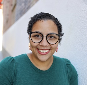 a picture of Alechia Dow in a green sweater