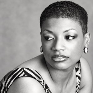 Black-and-white head-and-shoulders portrait of author Stella Simone Nichols, looking thoughtfully to the side against a soft gray background
