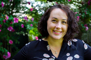 Photo of the author standing before a flowering tree