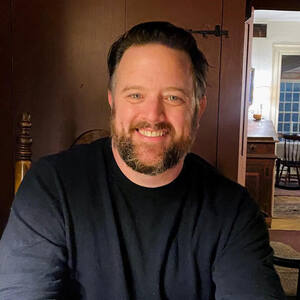 Caucasian man with brown hair smiling.