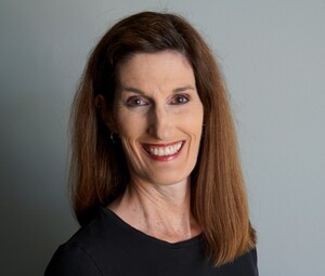 A woman with long dark brown hair and in a black shirt