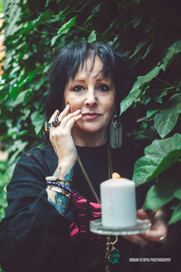 Woman holds a candle and looks at the camera
