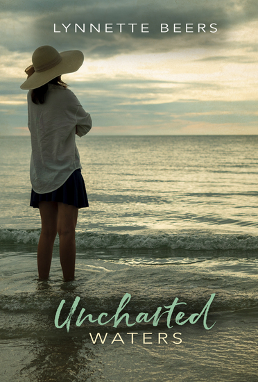 Woman in a wide-brimmed hat standing in front of the ocean