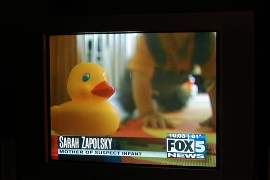 Yellow rubber duckie in forground, crawling toddler in background with Fox News IS, name, and title of "Mother of Suspect Infant."