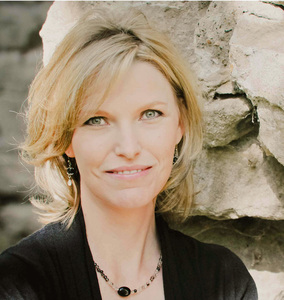 Headshot of Tracey with a stone wall backdrop