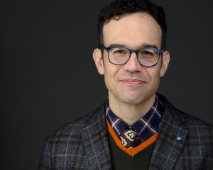 Daniel Rafinejad in a brown tie and light blue glasses. Photographed in Baltimore, 2020.
