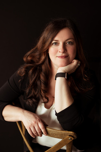 A photo of a white woman with brown hair and green eyes. 