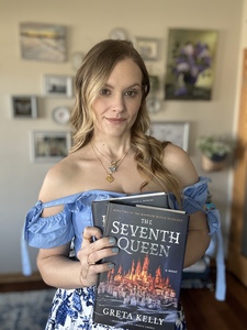 a photo of American author Greta Kelly, a blonde-haired white woman in a blue and white dress