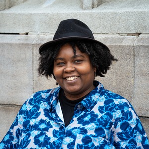 Rasheena Fountain in fedora and flower blue shirt 