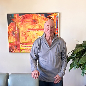 Jonathan Reeve Price stands in front of his picture of the Sun, in his digital art series, Spaceshots.