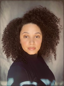 Profile picture of Kalynn Bayron in a black turtleneck against a gray background.