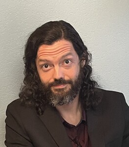A white man with a salt-and-pepper beard looking at the camera.