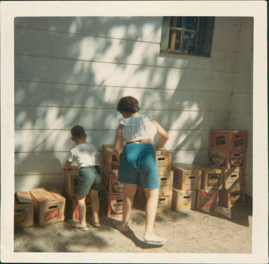 Young girl and boy stacking beer cases circa 1960s