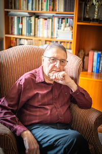 <img src="RZ6_7594.jpg" alt="Dennis Martin Brooks Photo-Seated on Chair in a Library">