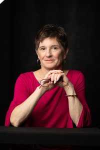 woman wearing pink shirt and holding glasses