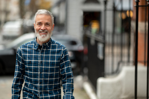 Paul Russell Garrett walking and smiling in checked shirt