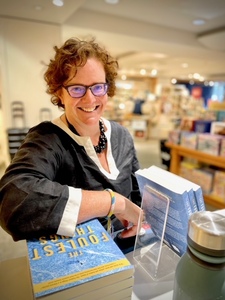 Photo of a woman leaning on books- Amy Tector leaning on The Foulest Things