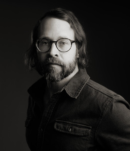 Image of a man with a beard wearing glass