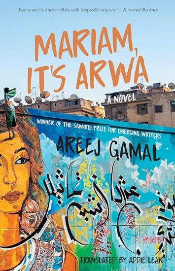 A brightly colored mural of a woman on a blue wall against a backdrop of buildings