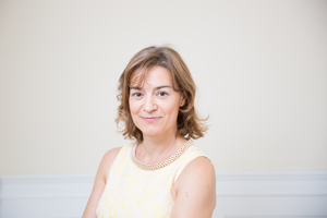 Photo of Leide Porcu with a  light background on a yellow dress