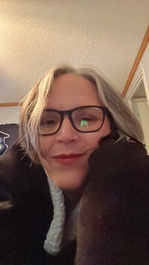 Wendee Mullikin, writing as Deelylah Mullin, looks at the camera with her cheek resting on her hand. 