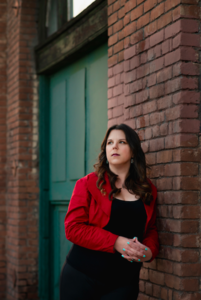Portrait of Rachael Warecki in front of a green door