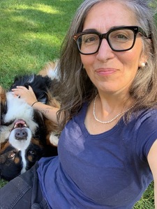 Vivian seated petting a dog on the chest