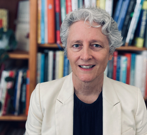 Picture of Anne Janzer in front of bookshelf