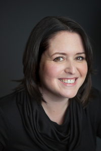 woman with dark hair and black shirt smiling
