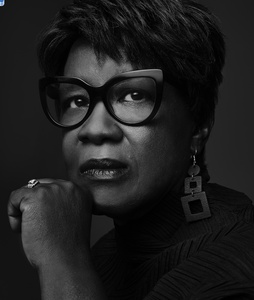 BW image of African-American woman wearing black-rimmed glasses